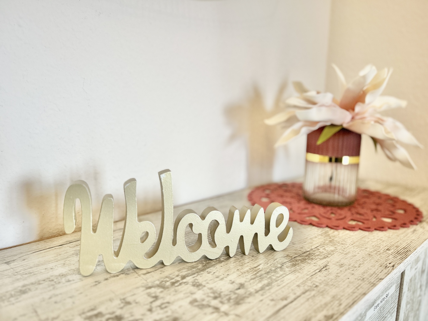 Welcome-Schriftzug auf einer Anrichte im Flur des Red Apartments Cottbus