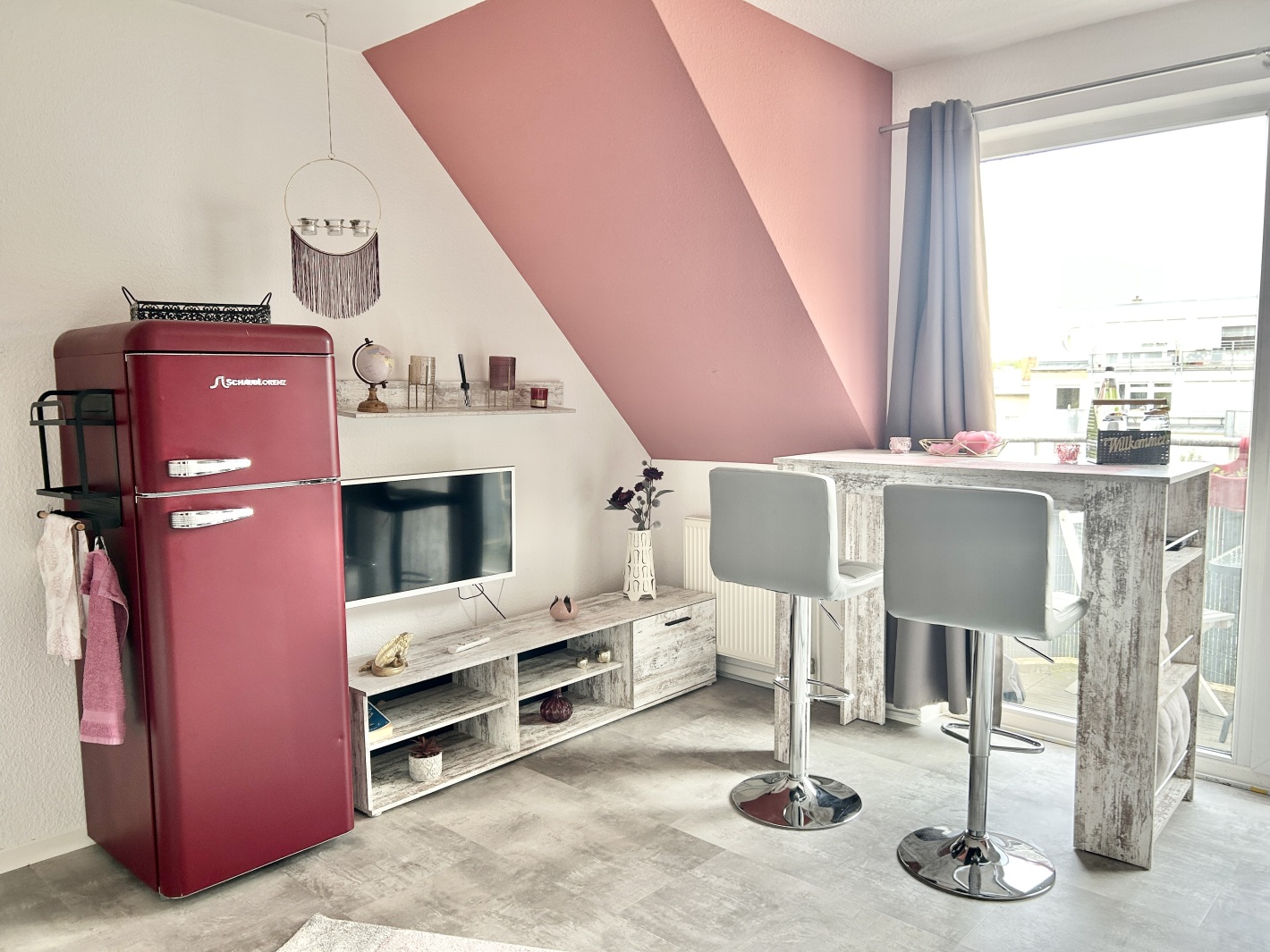 Stilvolles Wohnzimmer mit Retro-Kühlschrank und Bartisch im Red Apartment Cottbus