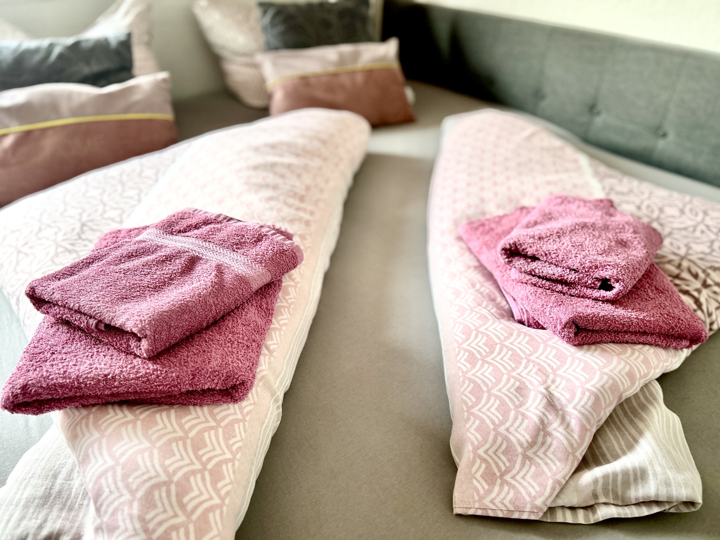 Frisch gefaltete Handtücher auf dem Bett im Red Apartment der Ferienwohnung Cottbus