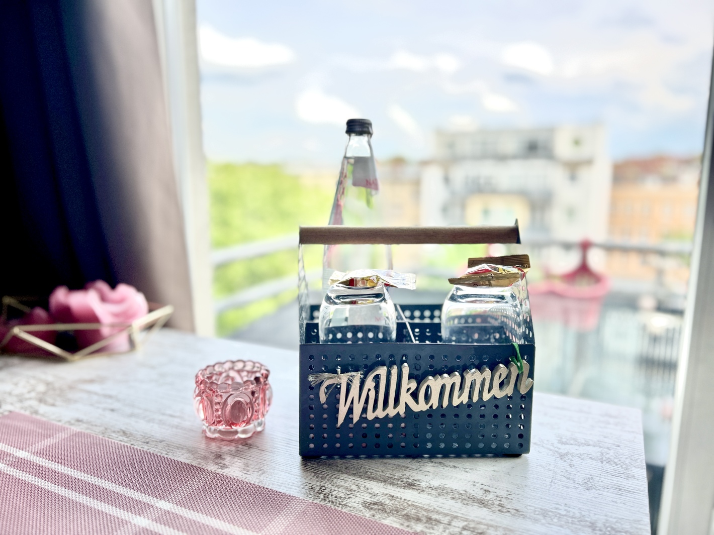 Willkommen-Schild und Glas auf dem Tisch im Red Apartment Cottbus