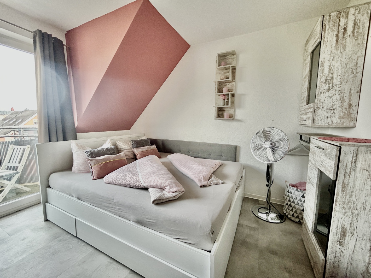 Gemachtes Bett mit stilvoller Deko im Schlafzimmer der Ferienwohnung Cottbus Red Apartment