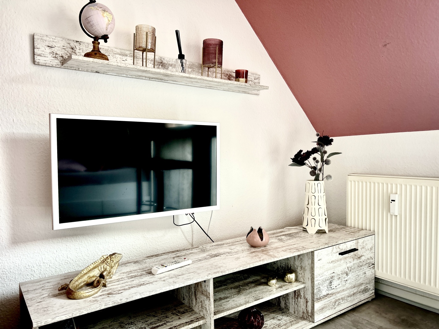 Flachbild-TV an der Wand im Wohnzimmer der Ferienwohnung Cottbus Red Apartment
