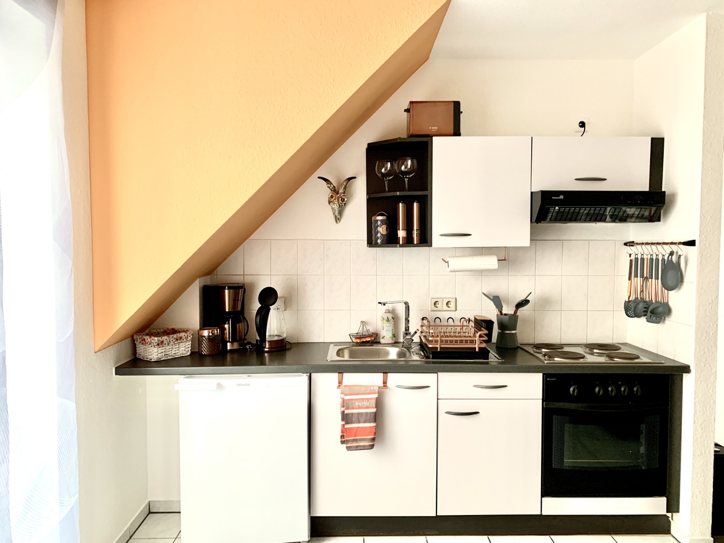 Kompakte Küche unter Dachschräge in der Ferienwohnung Cottbus mit Balkon