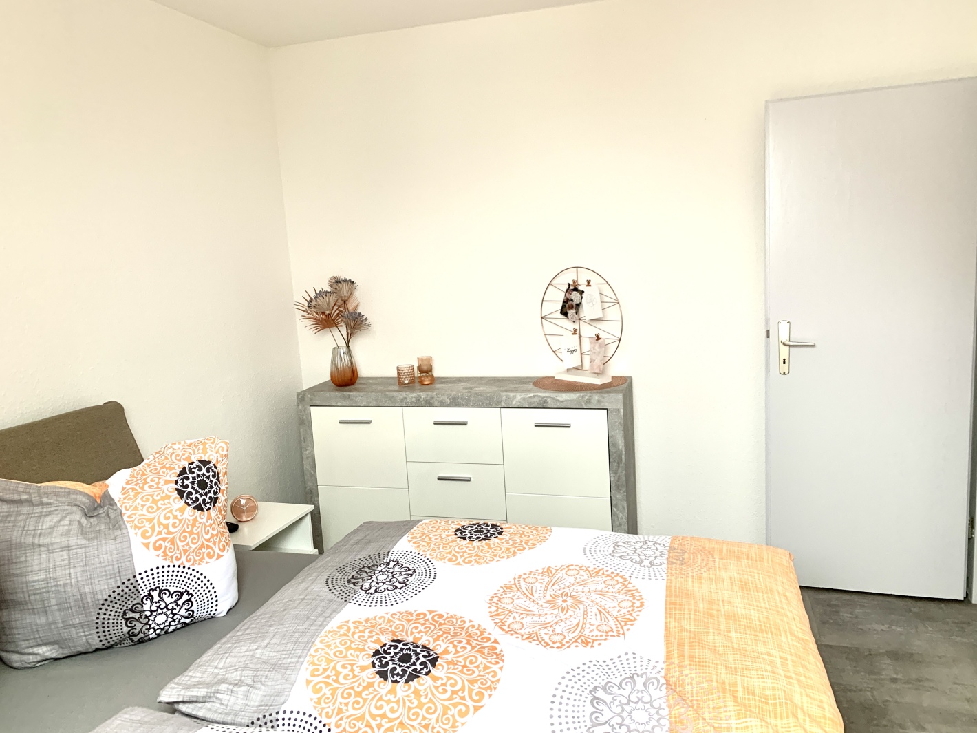 Weitwinkelaufnahme vom Doppelbett mit Kissenarrangement – Apricot Apartment