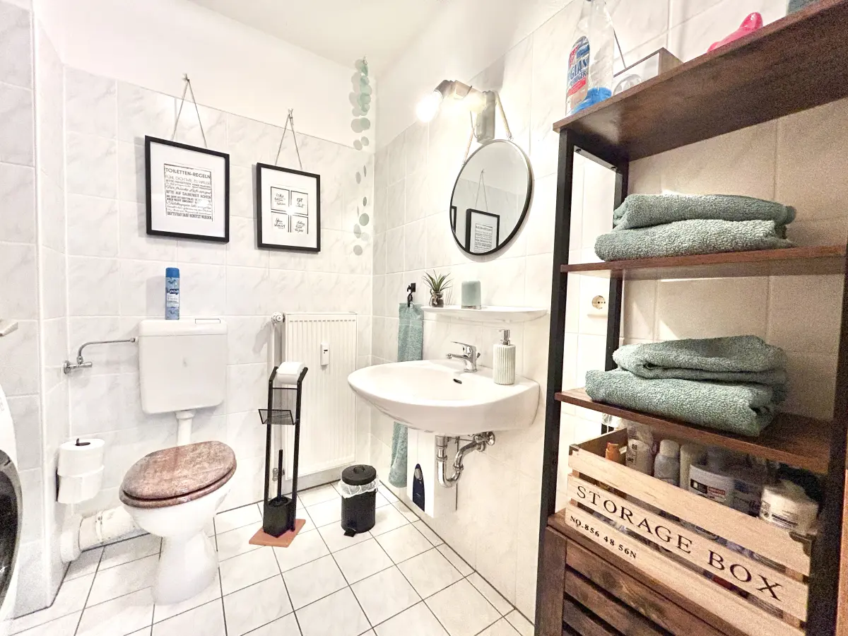 ferienwohnung-cottbus-green-apartment-bad Helles, modernes Badezimmer im Green Apartment Cottbus mit WC, Waschtisch und frischen Handtüchern in gepflegtem Zustand.