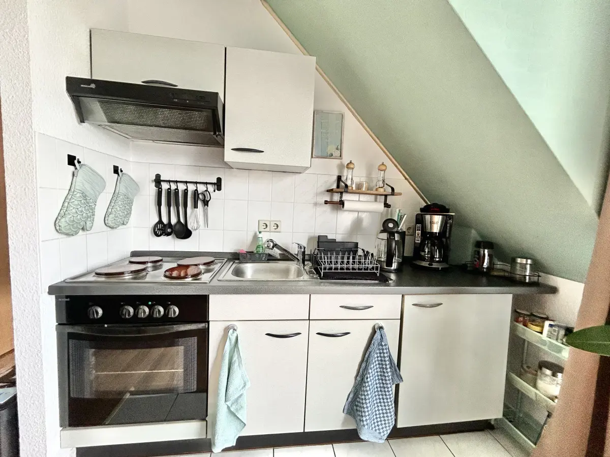 ferienwohnung-cottbus-green-apartment-kuechenzeile Moderne, voll ausgestattete Küchenzeile im Green Apartment Cottbus mit Herd, Backofen und Kaffeemaschine für Selbstversorger.