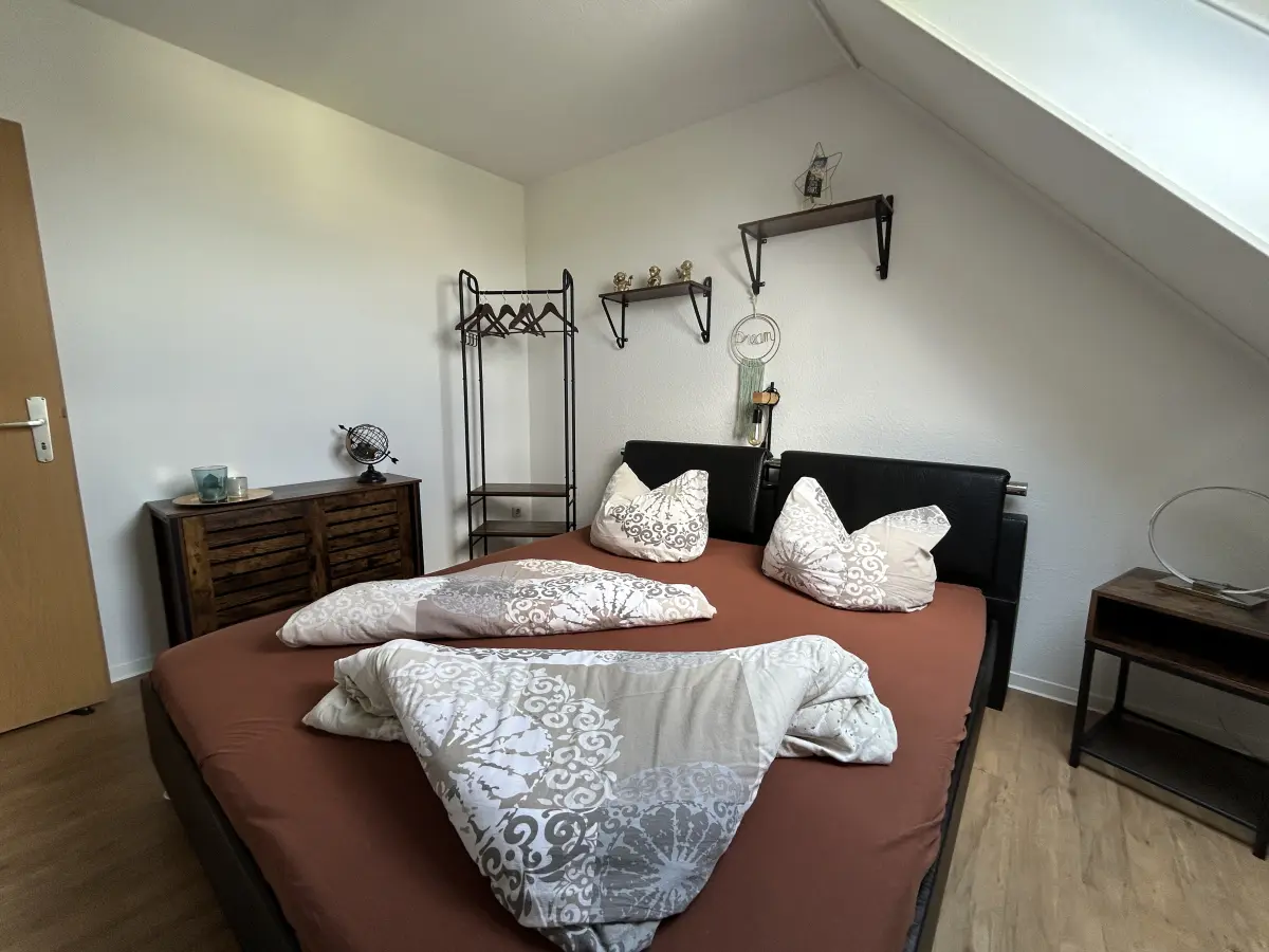 ferienwohnung-cottbus-green-apartment-schlafzimmer-bett Komplettansicht des Schlafzimmers im Green Apartment Cottbus mit modernem Doppelbett und Wanddekoration in ruhiger Hinterhof-Lage.