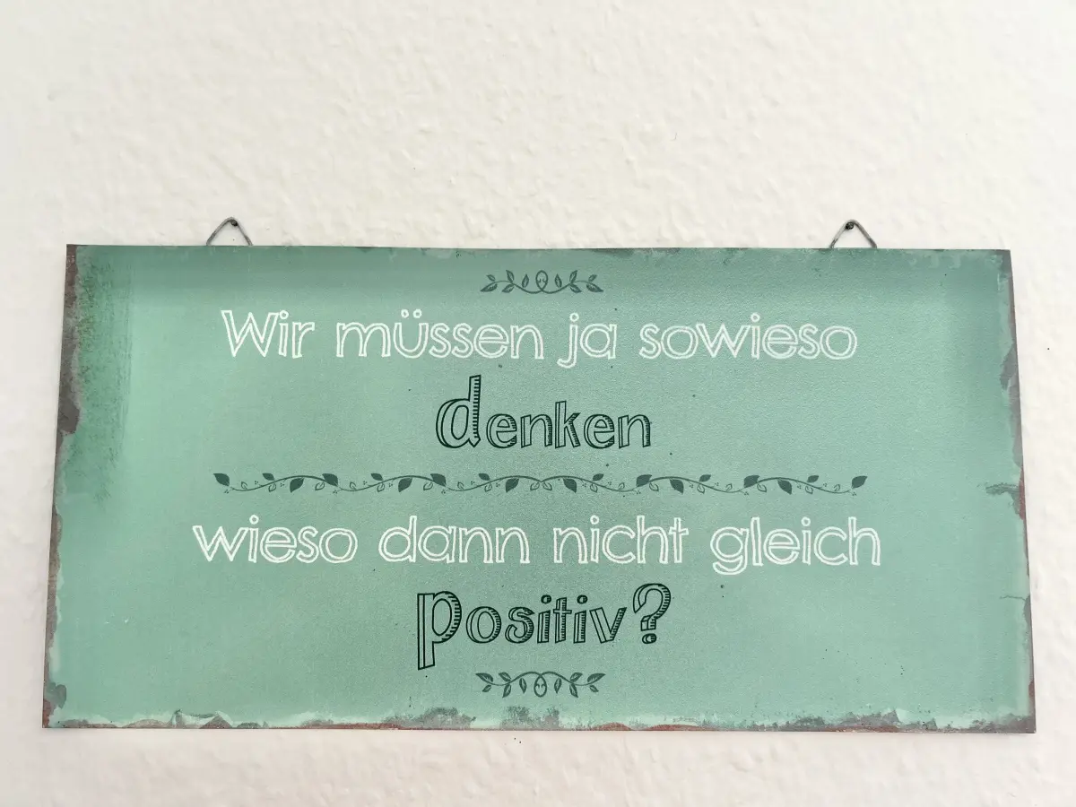 ferienwohnung-cottbus-green-apartment-wohnzimmer-deko Motivierendes Deko-Schild im Wohnbereich des Green Apartments Cottbus – moderne Ferienwohnung in zentraler Lage.