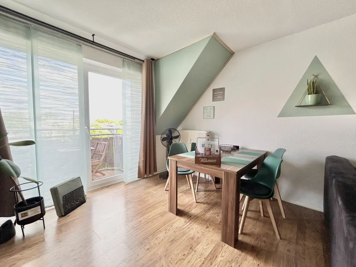 ferienwohnung-cottbus-green-apartment-wohnzimmer-esstisch Moderner Essbereich im Green Apartment mit direktem Zugang zum Balkon – Ihre zentrale Ferienwohnung in Cottbus.
