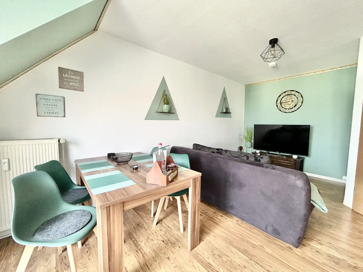 ferienwohnung-cottbus-green-apartment-wohnzimmeransicht Großzügiges Wohnzimmer mit Smart-TV und gemütlichem Sofa im Green Apartment, eine zentrale und ruhig gelegene Ferienwohnung in Cottbus.